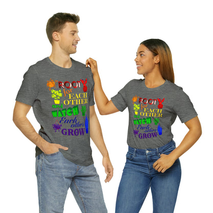 A vibrant t-shirt featuring a beautiful design of rainbow-colored plants. The phrase 'Root for each other and watch each other grow' is prominently displayed on the shirt. The design represents unity, support, and personal growth.