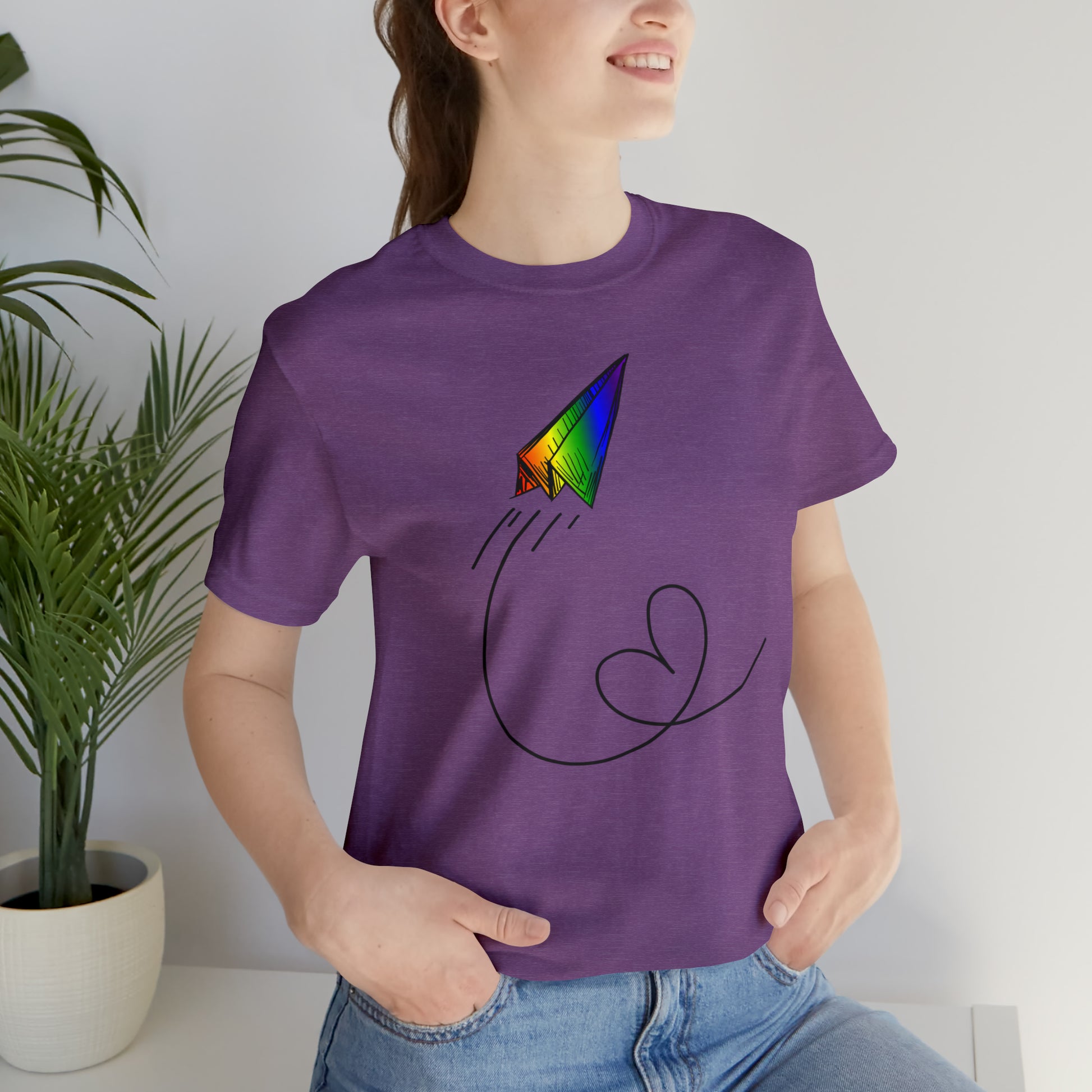 A vibrant t-shirt featuring a paper airplane design in the Pride rainbow colors. The rainbow colors symbolize LGBTQ+ pride and inclusivity.