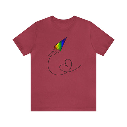 A vibrant t-shirt featuring a paper airplane design in the Pride rainbow colors. The rainbow colors symbolize LGBTQ+ pride and inclusivity.