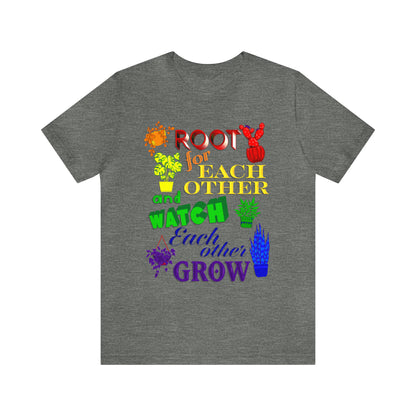 A vibrant t-shirt featuring a beautiful design of rainbow-colored plants. The phrase 'Root for each other and watch each other grow' is prominently displayed on the shirt. The design represents unity, support, and personal growth.